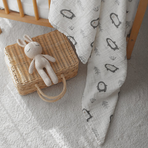 Close-up of penguin swaddle fabric with pacifier and basket