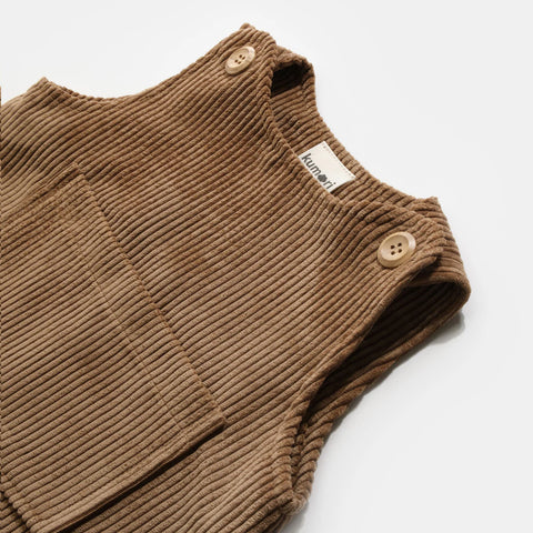 Close-up of wooden buttons and front pocket on brown baby corduroy overalls