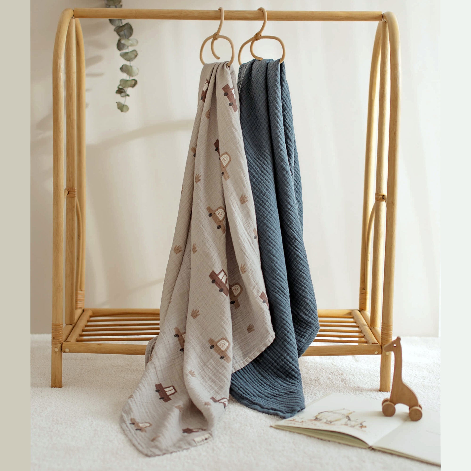 Cars swaddle and navy blanket hanging from a rack