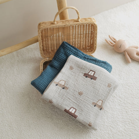 Cars swaddle and navy blanket neatly folded in a basket