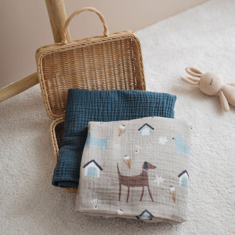 Dog print swaddle and navy blanket in a basket display