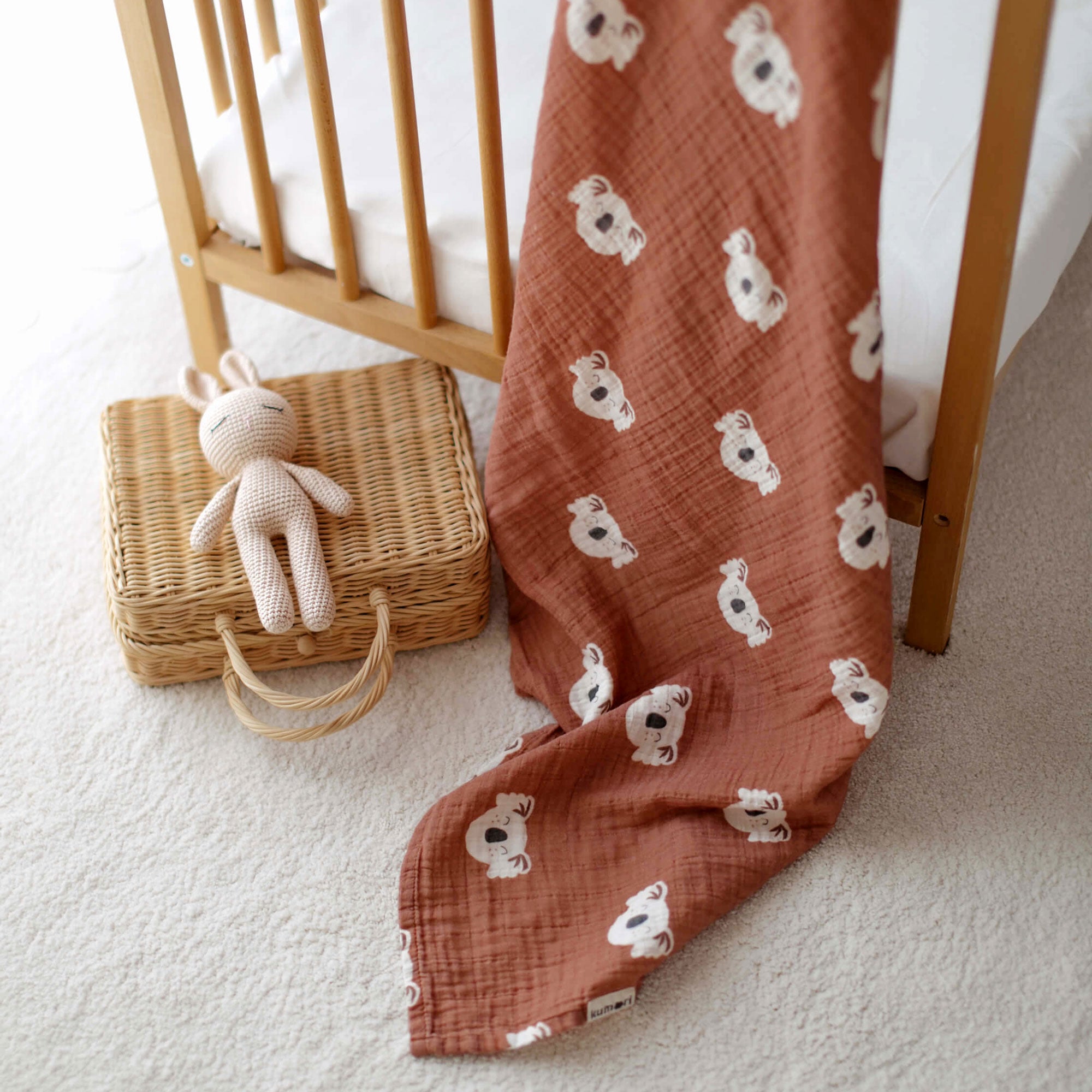Texture close-up of koala swaddle with basket and toy