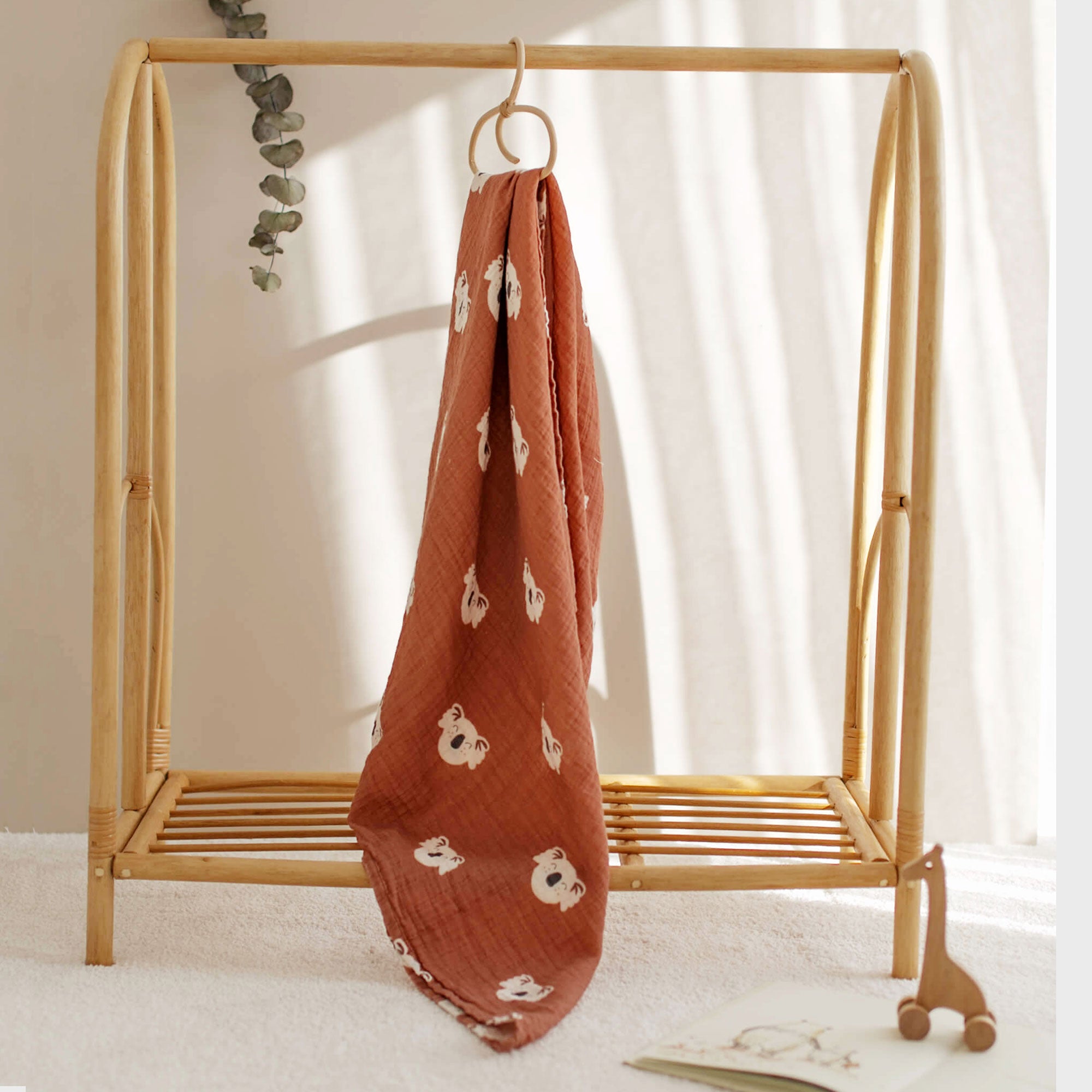 Koala muslin swaddle hanging from bamboo baby rack