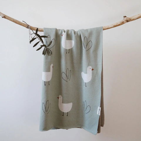 Full view of Minty Duck knit baby blanket hanging to show entire design