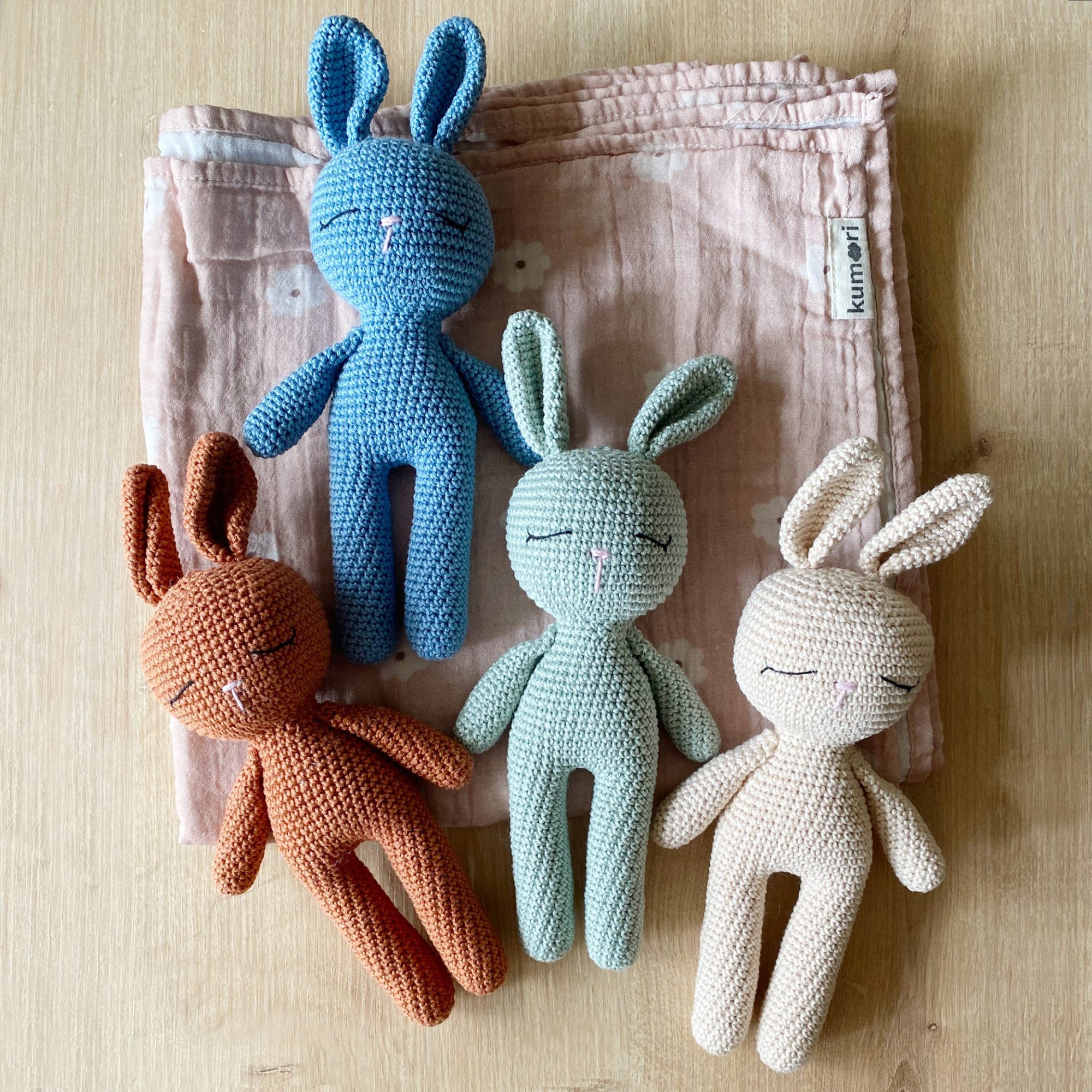 Group of crochet bunnies in mint, cinnamon, blue, and cream