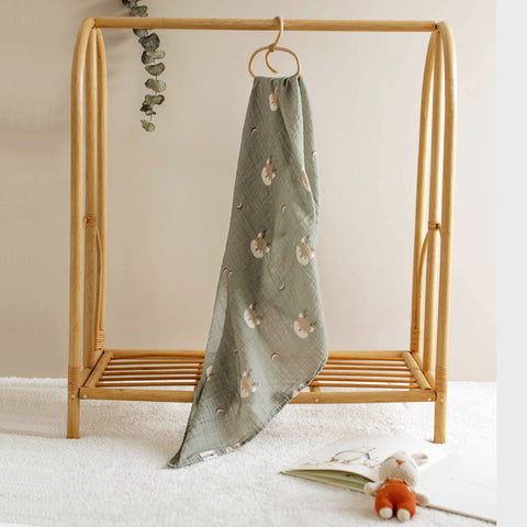 Forest Deer print baby swaddle shown hanging from wooden peg 